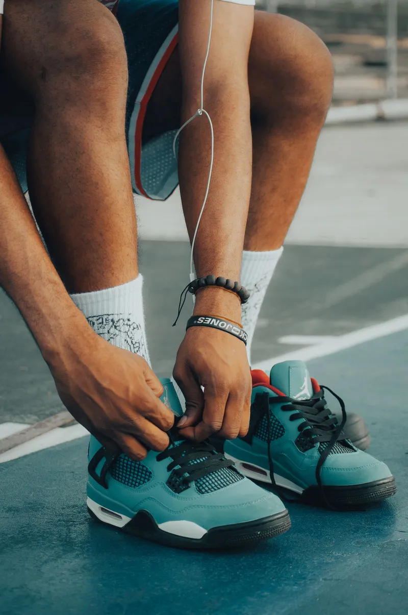 Persona atándose los cordones de las zapatillas