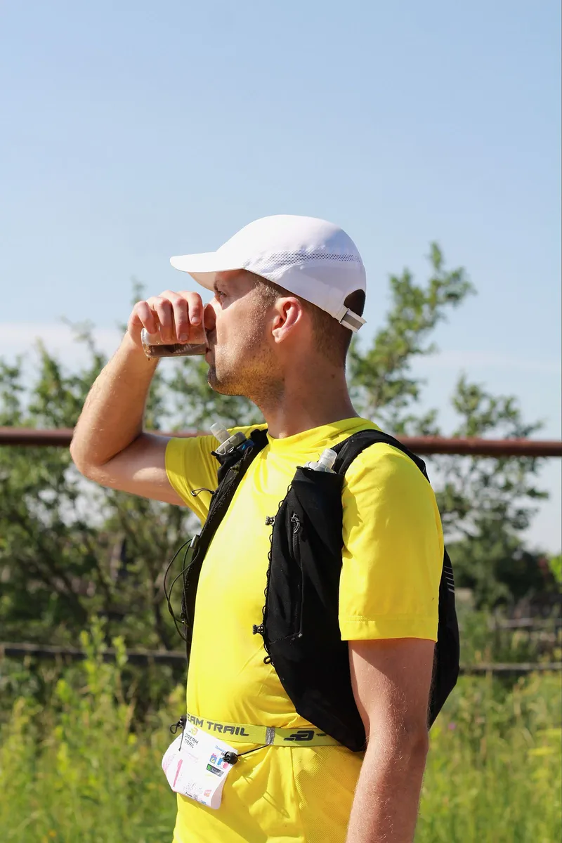 Corredor hidratándose con una botella de agua en un día caluroso de verano