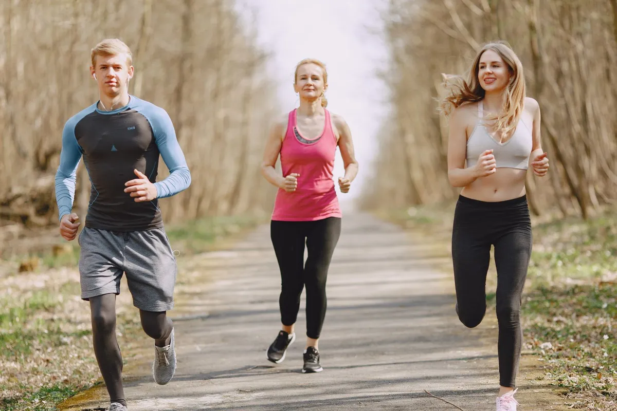 Tres personas trotando juntas por un parque un día de entrenamiento