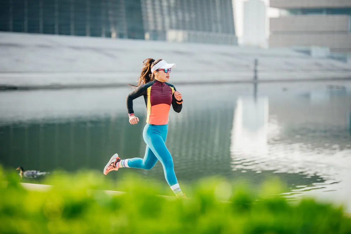 Mujer corriendo junto a un lago en un parque